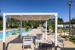 a pavilion with tables and chairs next to a pool at Detached villa with 2 bathrooms in Lupetto