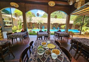 a dining room with tables with plates of food at An Riverside Ecolodge in Nguyên Ngoại