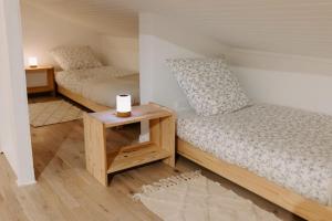 a bedroom with two beds and a night stand with a table at Maison Audrey avec jardin in Vulaines-sur-Seine