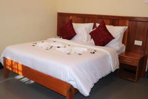 a bed with red and white sheets and flowers on it at Blue Junction Eco Lodge in Arusha