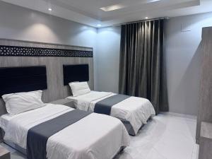 Una habitación de hotel con dos camas y una ventana. en روح الوزيرية, en Yeda