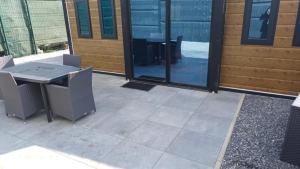 a patio with a table and chairs next to a building at La sérénité in Froid-Chapelle