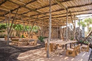 a picnic area with tables and benches under a roof at Relais Regina Giovanna in Sorrento