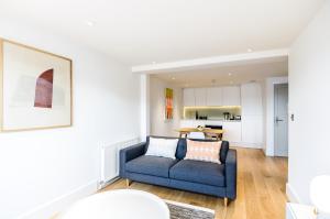 a living room with a blue couch and a table at Native Fulham in London