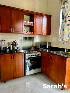 a kitchen with wooden cabinets and a stove top oven at Sarahs in Kampala +5 photos