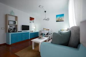a living room with a blue couch and a table at Marody House Vacacional in Granadilla de Abona