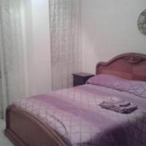 een slaapkamer met een bed met een paarse deken bij Alloggio S. Agostino in Sciacca