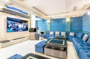 a living room with a blue couch and a tv at Villa Atchara in Patong Beach