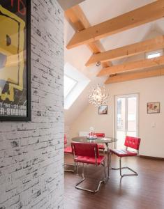 una sala da pranzo con un tavolo e sedie rosse di Scharhörn-Riff - 18 a Cuxhaven Altre 10 foto
