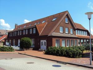 a large brick building with a brown roof at Leuchtturm in Juist
