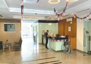 a man standing at a counter in a restaurant at Cozy Hotel Primera Suite Cyberjaya in Cyberjaya