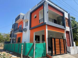 an orange and white house with a green fence at Pondicherry homestay - beach house 8 to 10 people in Kottakupam