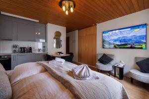 a bedroom with a large television on the wall at Luxe Davos Studio Central Walk to Lifts in Davos