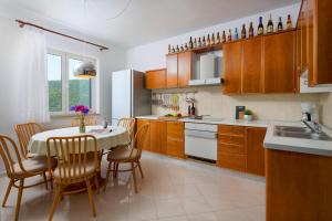 uma cozinha com mesa e cadeiras e uma cozinha com armários de madeira em Ana Apartment em Rabac