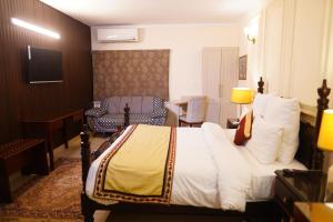 a hotel room with a bed and a chair at The Monterey Grand Hotel in Lahore