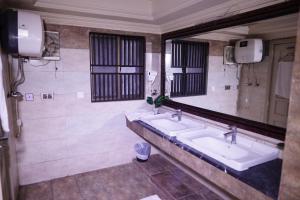 a bathroom with two sinks and a large mirror at The Monterey Grand Hotel in Lahore
