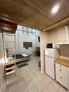 Una cocina con nevera y una habitación con cama. en Cozy Suites, en Tallin
