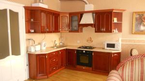 a kitchen with wooden cabinets and a stove top oven at Old Town Apartments in Lviv