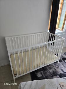 a crib in the corner of a room at Logement moderne équipé in Ouzouer-sur-Loire