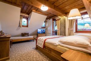 1 dormitorio con 1 cama y TV en una habitación en Penzion Viktória en Ždiar