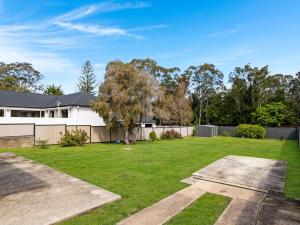 a yard with a fence and a house at Beachfront Escape Relaxing Getaway in Batehaven in Sunshine Bay