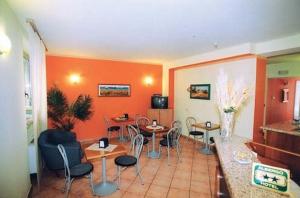 ミラノにあるホテル イリーデのテーブルと椅子が備わるオレンジ色の壁の客室です。