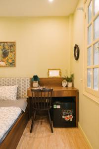 une chambre avec un bureau avec une chaise et un lit dans l'établissement Anchie Vintage Homestay - Train Street Hanoi, à Hanoï