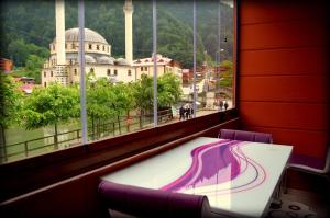 a table with a view of a building from a window at Osmanlı Suite in Uzungöl