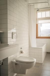 a white bathroom with a toilet and a window at Hotel Isafjordur - Horn in Ísafjörður
