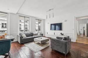 a living room with couches and a table at BnBNova - 3BR - Champs Élysées in Paris