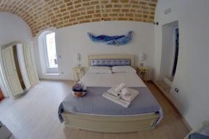 1 dormitorio con 1 cama grande y toallas. en Palazzo Piccioli en Gallipoli