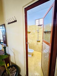 a bathroom with a toilet and a glass door at Low budget double room in Paje in Paje