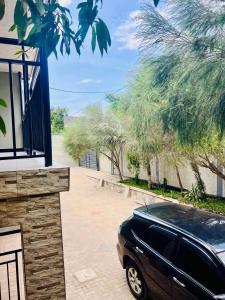 a black car parked in a driveway next to a building at Sunset Inn Lodge in Arusha