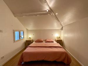 a bedroom with a bed with two pillows on it at Maison cosy à côté de Beaune in Savigny-lès-Beaune