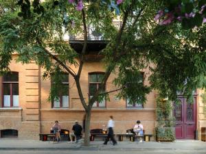 a group of people sitting at tables in front of a building at Bellhop Tbilisi in Tbilisi City