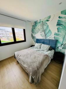une chambre avec un lit et une grande fresque murale sur le mur dans l'établissement Apartament z Basenem i Jacuzzi Benidorm Finestrat, à Finestrat