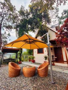 an umbrella and three baskets in front of a house at The Attic By Snovika The Organic Farm in Bhīm Tāl