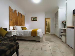 a bedroom with a bed and a living room at Wag-n-Bietjie in Centurion