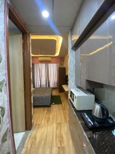 a small room with a kitchen with a microwave at Kaveri City Center in Greater Noida