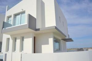 a white house with a balcony at T&E Villa in Larnaca