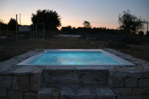 a hot tub in a stone wall in a yard at La Casa di Gioia - Dimora Rurale in Trappeto