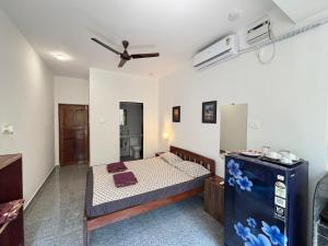 a bedroom with a bed and a ceiling fan at Studio Arambol Hideaway R4 by Mukund Sadan Arambol in Arambol +7 photos