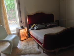 a bedroom with a bed and a chair and a window at PROVENCEguesthouse L'Agace in Forcalquier