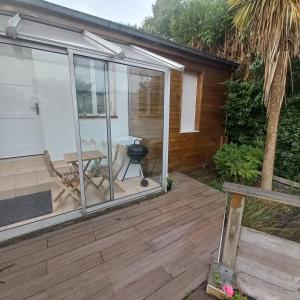 a patio with sliding glass doors and a grill at Maison au calme avec jardin et grande terrasse in Brest