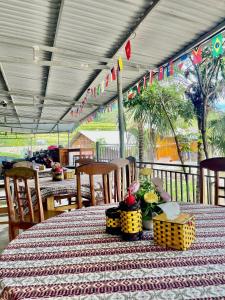 ein Tisch mit Blumen darauf mit Stühlen und Fahnen in der Unterkunft Chin Chin House Trekking & Homestay in Sa Pa