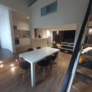 a kitchen and dining room with a white table and chairs at Maison au calme avec jardin et grande terrasse in Brest