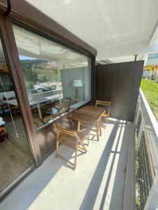 a patio with a table and chairs on a balcony at L'Éterlodge Cosy - Studio au pied des pistes à Chamrousse - Ski in - Ski out - 4 personnes in Chamrousse
