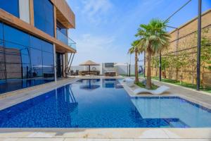 an infinity pool in a building with palm trees at Nagawa Staycation in á¸¨aÅŸat al BidÄ«yah