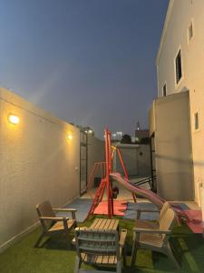 un parco giochi con sedie e uno scivolo su un edificio di Holiday Home Al Taif Al Wisam a Taif