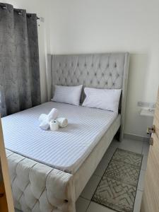 Una cama con dos animales de peluche encima. en Daniel Homes, en Mombasa